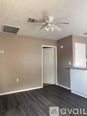 Bryan apartment for rent - A room with a ceiling fan and a door.