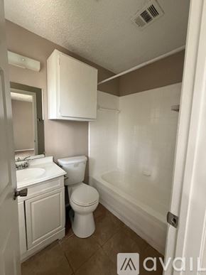 Bryan apartment for rent - A white toilet sits in a bathroom next to a sink.