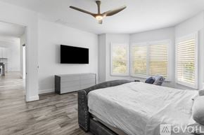 Winter Garden house for rent - A bedroom with a large bed and a ceiling fan.