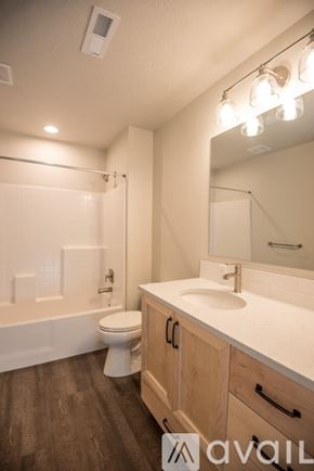 Fruitland apartment for rent - A bathroom with a toilet, sink, and mirror.