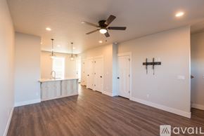 Fruitland apartment for rent - A spacious room with a ceiling fan and wooden flooring.