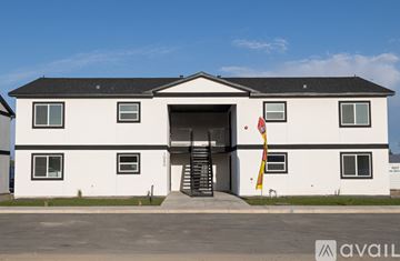 Payette apartment for rent - A white building with a black roof and a flag in front.