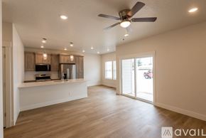 Payette apartment for rent - A spacious living room with a ceiling fan and sliding glass doors.