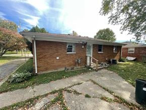 Jeffersonville house for rent - A small brick house with a porch and a tree in front.