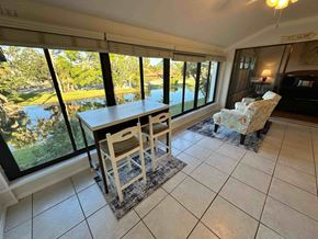 Bradenton house for rent - A dining room with a table and chairs with a view of a lake.