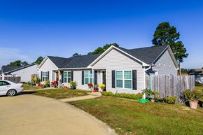 Raeford apartment for rent - A house with a grey roof and a white car parked in front.