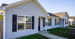 Raeford apartment for rent - A house with a grey siding and black shutters.