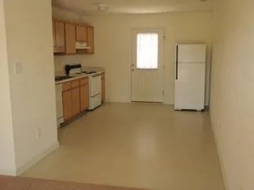 Raeford apartment for rent - A kitchen with white appliances and wooden cabinets.