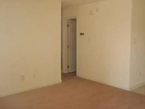 Raeford apartment for rent - A room with a brown carpet and a white door.