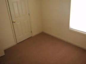 Raeford apartment for rent - A room with a brown carpet and a white door.