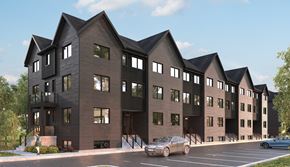 London apartment for rent - A modern building with a black facade and a parking lot in front.