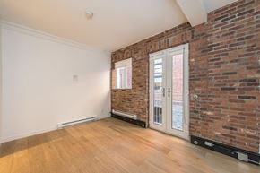 Victoria apartment for rent - A room with a brick wall and a sliding glass door.