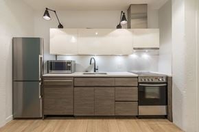 Victoria apartment for rent - A modern kitchen with a refrigerator, microwave, oven, and sink.