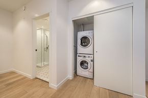 Victoria apartment for rent - A white laundry room with a washer and dryer in a cabinet.