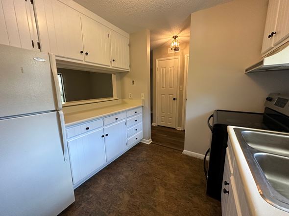 Winston Salem apartment for rent - A kitchen with white cabinets and a white refrigerator.