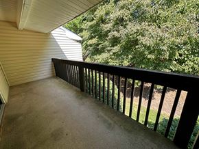 Winston Salem apartment for rent - A balcony with a black railing and a view of trees.