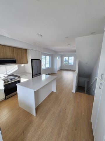 Victoria apartment for rent - A modern kitchen with wooden floors and white walls.