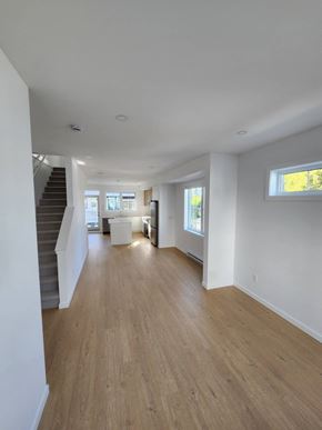 Victoria apartment for rent - A long hallway with wooden floors and white walls.