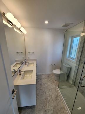Victoria apartment for rent - A bathroom with a walk in shower and a toilet.