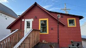 Sitka apartment for rent - A red house with a white door and yellow window frames.