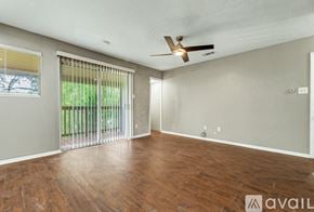 Bryan apartment for rent - A room with wooden floors and a ceiling fan.