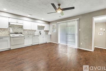 Bryan apartment for rent - A spacious kitchen with white cabinets and a ceiling fan.