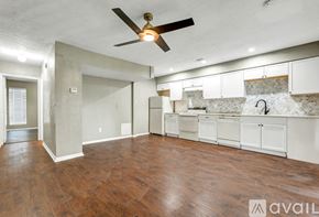 Bryan apartment for rent - A spacious room with a ceiling fan and wooden flooring.