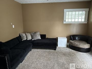 Warren house for rent - A living room with a black couch and ottoman.