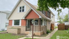 Milwaukee house for rent - A house with a red trim and a porch with a black railing.