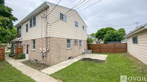 Milwaukee house for rent - A house with a beige siding and a brown fence is for sale.
