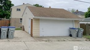 Milwaukee house for rent - A house with a garage and three bins in front.