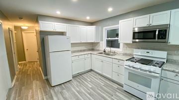 Milwaukee house for rent - A kitchen with white appliances and cabinets.