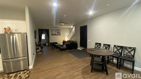 Dallas house for rent - A kitchen with a refrigerator, a dining table with chairs, and a ceiling fan.