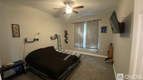 Dallas house for rent - A bedroom with a bed, a ceiling fan, and a window with curtains.