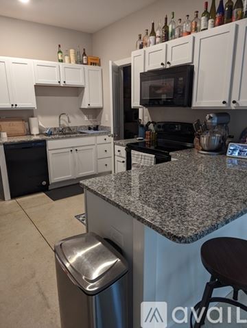 Wichita townhouse for rent - A kitchen with granite countertops and white cabinets.