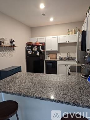 Wichita townhouse for rent - A kitchen with granite countertops and white cabinets.