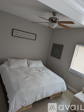 Wichita townhouse for rent - A bedroom with a bed, a ceiling fan, and a picture on the wall.