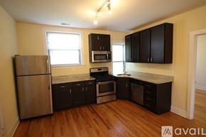 Chicago apartment for rent - A kitchen with wooden floors and a stainless steel refrigerator.