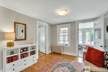 Newton apartment for rent - A living room with a white couch and a rug on the floor.