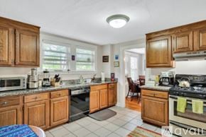 Newton apartment for rent - A kitchen with wooden cabinets and a white countertop.