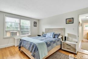 Newton apartment for rent - A bedroom with a bed, nightstand, and window.