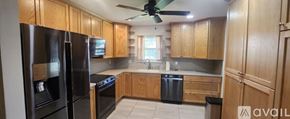 Dade City house for rent - A kitchen with wooden cabinets and black appliances.