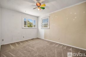 Grand Junction townhouse for rent - A room with a ceiling fan and two windows.