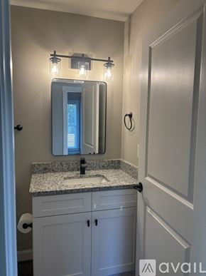 Mount Airy house for rent - A bathroom with a granite countertop and a mirror above it.