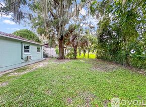 Ocala house for rent - A backyard with a green lawn and trees.