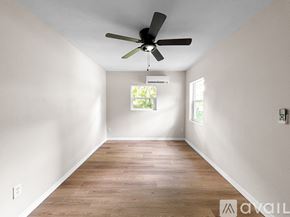 Ocala house for rent - A room with a ceiling fan and wooden flooring.