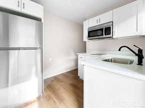 Ocala house for rent - A kitchen with white cabinets and a white fridge.