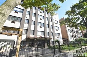 Chicago apartment for rent - A tall residential building with a black gate in front.