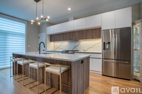 Chicago apartment for rent - A modern kitchen with wooden stools and a stainless steel refrigerator.
