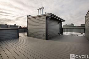 Chicago apartment for rent - A wooden deck with a small building and a metal railing.